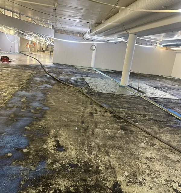 Klargjort gulv med slange før støping i stort industrilokale